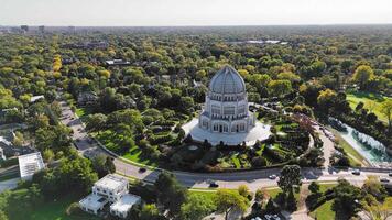 Aerial view of Bahai Temple surrounded by greenery. Aerial shot of a large white domed temple with intricate architecture, surrounded by gardens, trees, and nearby residential areas. video