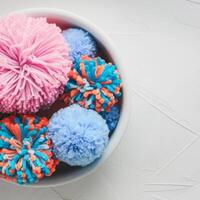 Colorful pom poms in a bowl photo