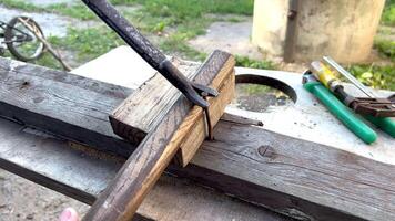 Worker removing nails from wooden plank using claw hammer and block video