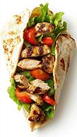 Grilled chicken wrap filled with fresh vegetables served in a flatbread on a white background photo