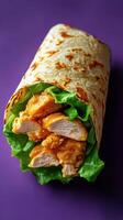 Delicious chicken wrap filled with crispy chicken and fresh lettuce on a vibrant background photo