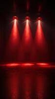 Red spotlight beams illuminate a darkened indoor space creating dramatic shadows and atmosphere for an event photo