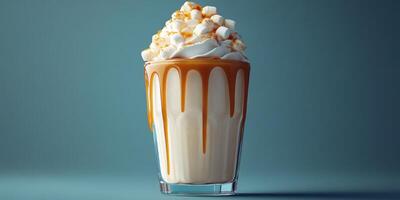 Delicious dessert drink with whipped cream and caramel topping in a clear glass on a blue background photo