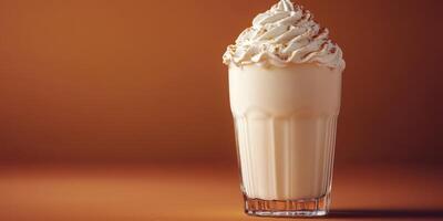 Creamy vanilla milkshake topped with whipped cream and caramel sprinkled on a warm background photo