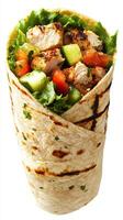 Grilled chicken wrap with fresh vegetables and herbs in a tortilla enjoyed at a casual dining setting photo