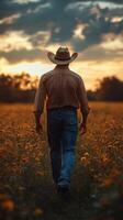 Cowboy walks through a golden field during sunset with dramatic clouds in the background photo
