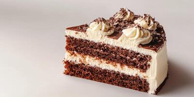 Chocolate cake slice with creamy frosting and chocolate shavings on top presented on a neutral background photo