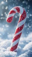 Colorful candy cane nestled in fresh snow with sparkling bokeh effects during winter season photo
