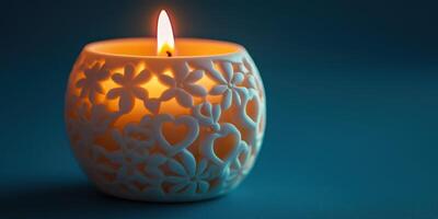 Decorative candle holder with floral design casting warm light on blue background photo