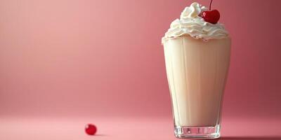 Creamy milkshake topped with whipped cream and cherry on pink background photo