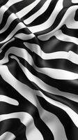 Black and white zebra print fabric draped elegantly across a surface in soft, flowing waves photo