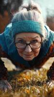 Elderly woman exercises outdoors, showcasing strength and resilience during morning workout in a natural setting photo