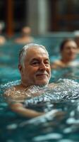 Senior man enjoying a relaxing swim in a serene indoor pool surrounded by other swimmers during daylight hours photo