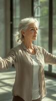 Senior woman practicing yoga in a serene studio with natural light during morning hours photo