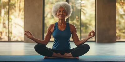 Senior woman practicing yoga in a bright studio with large windows during morning hours photo