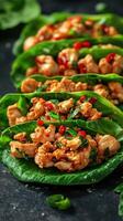 Delicious chicken lettuce wraps served on a dark plate with fresh herbs and spices in an appetizing arrangement photo