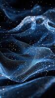 Colorful particles float in waves of translucent fabric on a dark background photo