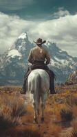 Cowboy riding a white horse through a rugged landscape with mountains in the distance on a cloudy day photo