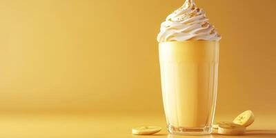 Creamy banana milkshake topped with whipped cream and golden sprinkles on a warm yellow background photo