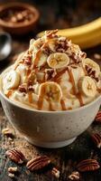Delicious whipped cream dessert topped with bananas and pecans served in a white bowl on a rustic wooden table photo