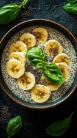Creamy chia pudding topped with fresh banana slices and basil leaves in a rustic bowl photo