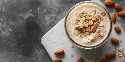Nutritious almond smoothie topped with oats on a gray background for a healthy lifestyle photo