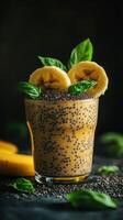 Healthy banana chia seed smoothie with fresh basil leaves and banana slices served in a glass cup photo