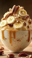 Delicious bowl of ice cream topped with caramel, bananas, and pecans on a wooden table perfect for dessert lovers photo