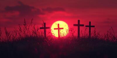 Sunset casts a warm glow on three crosses silhouetted against a vibrant sky in a serene grassy field photo