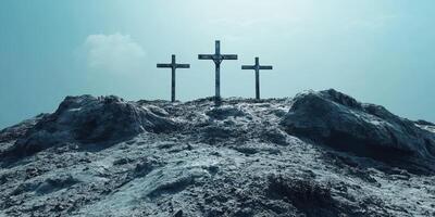 Three weathered crosses stand on a barren hill under a bright blue sky and soft clouds photo