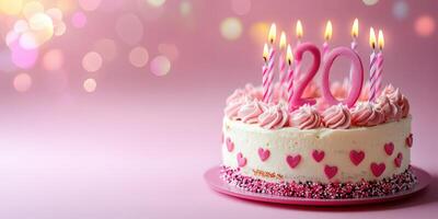 Birthday cake with pink frosting and candles celebrating 20th birthday on a festive background photo