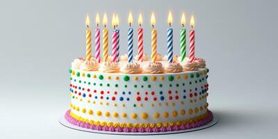 Colorful birthday cake with candles illuminated against neutral background photo