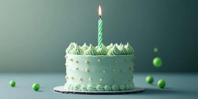 Mint green birthday cake adorned with a candle and decorative accents on a simple backdrop photo