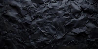 Crumpled black paper texture showcasing intricate folds and shadows in artistic, abstract form photo