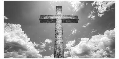 Stone cross stands tall against a dramatic sky filled with clouds during midday light in a peaceful outdoor setting photo