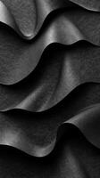Layers of black textured fabric create a mesmerizing wave pattern in soft light, showcasing rich depth and elegance in design photo