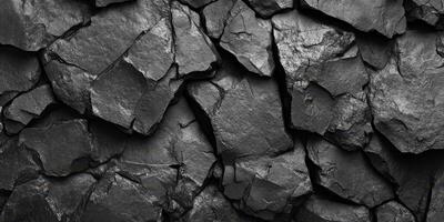 Dark textured stones arranged closely creates an interesting backdrop for various design projects or artistic expressions photo