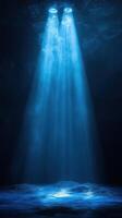 Bright blue lights shining down into a dark cavern creating an ethereal atmosphere underwater photo