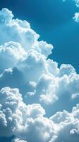 Bright white clouds billow against a vivid blue sky during a sunny afternoon photo