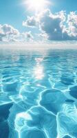 Bright sunlight reflects on calm turquoise ocean waves under a blue sky with fluffy clouds photo