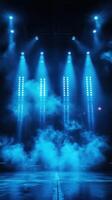 Blue stage lights illuminate a fog-filled performance space at night during a live event photo