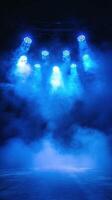 Bright blue stage lights shine through a foggy atmosphere during an evening performance photo