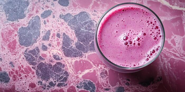 Bright pink beverage on a marbled surface showcases vibrant colors and appealing textures in a culinary setting photo