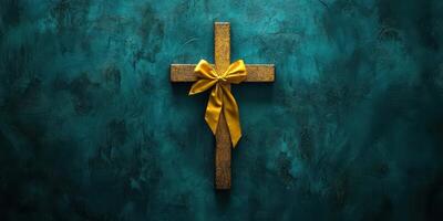 Decorative golden cross with bow against a textured teal background during a religious celebration photo