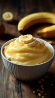 Creamy banana pudding served in a bowl with fresh bananas in the background on a wooden table photo