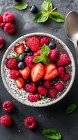 Fresh berry bowl with yogurt and mint served on a dark stone table for a healthy breakfast or snack photo