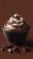 Rich chocolate swirl dessert served in a black bowl with chocolate shavings on top photo