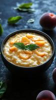 Creamy rice pudding topped with fresh peach slices and mint leaves in a dark setting photo