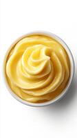 Creamy yellow dessert in a white bowl with a smooth swirl, perfect for various sweet dishes and toppings photo