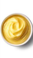 Creamy yellow substance in a white bowl, showcasing a smooth texture, ideal for culinary uses and desserts photo